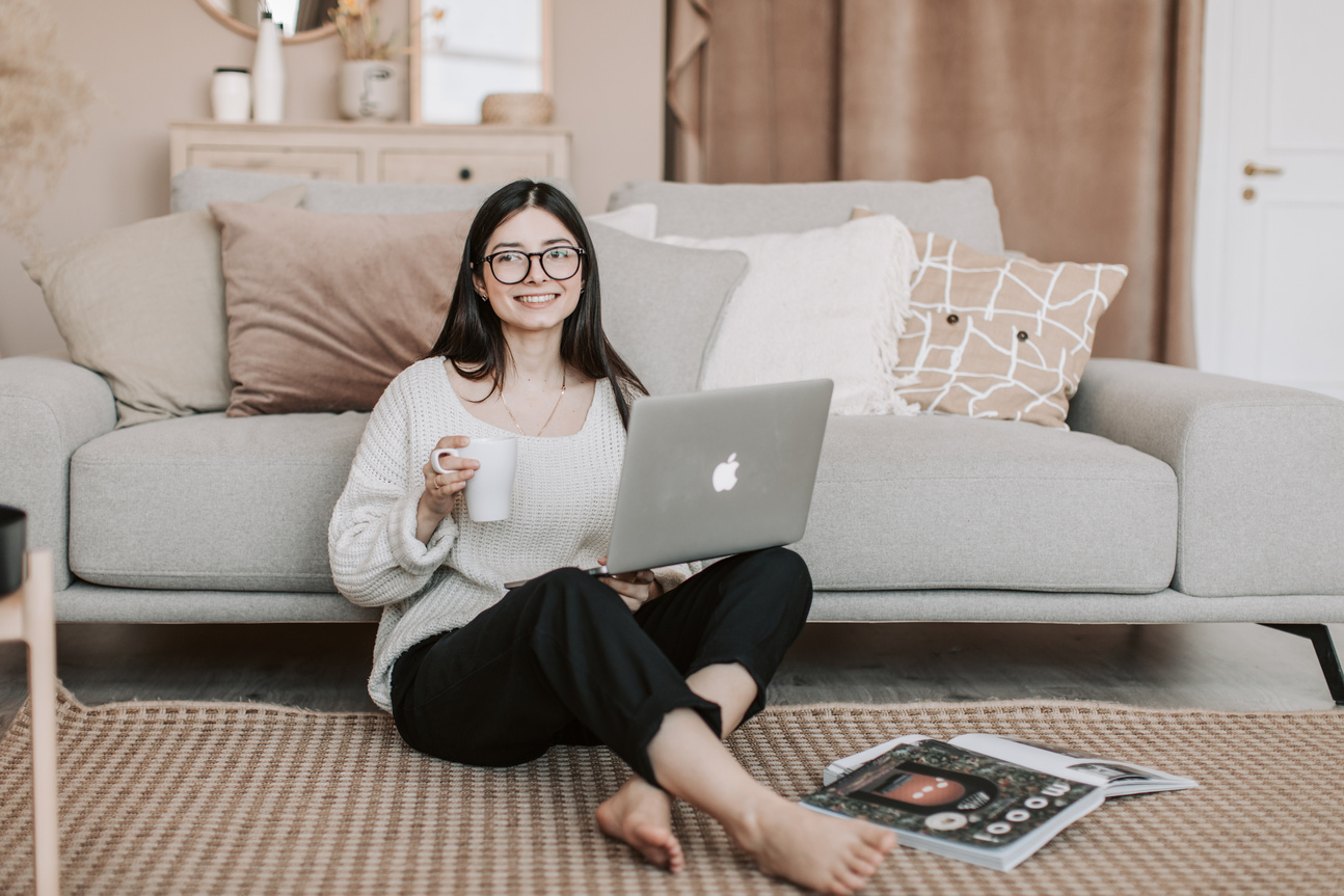 Cheerful woman using laptop at home